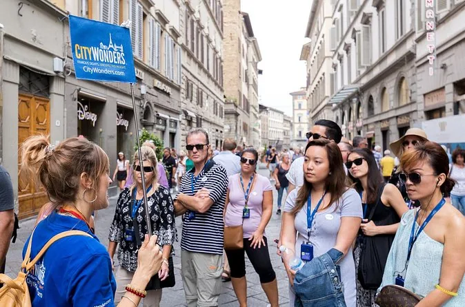 Un guide conduisant un petit groupe le long d'une rue de Florence